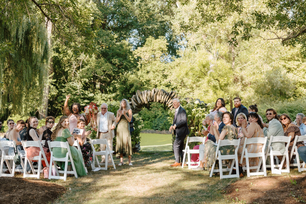 Non-traditional Vermont wedding ceremony at the Intervale Center with friends and family gathered outdoors.