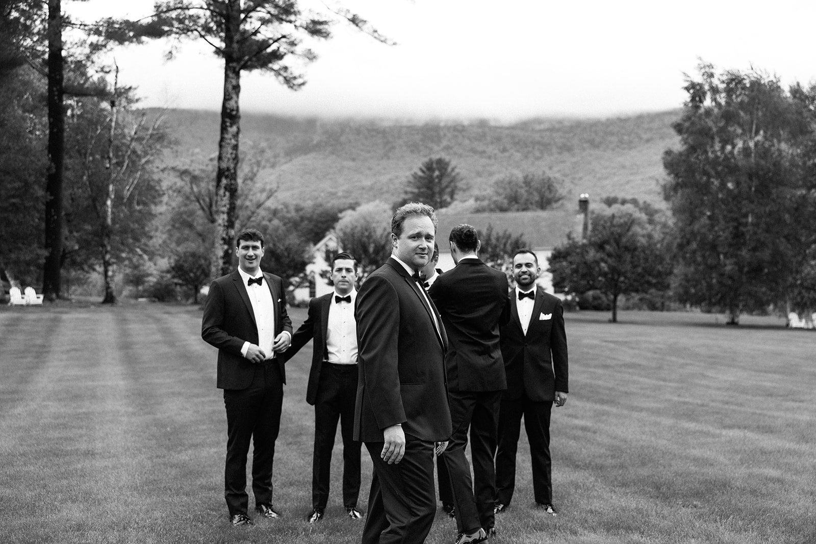 candid photo of groomsmen on the lawn at the inn at manchester