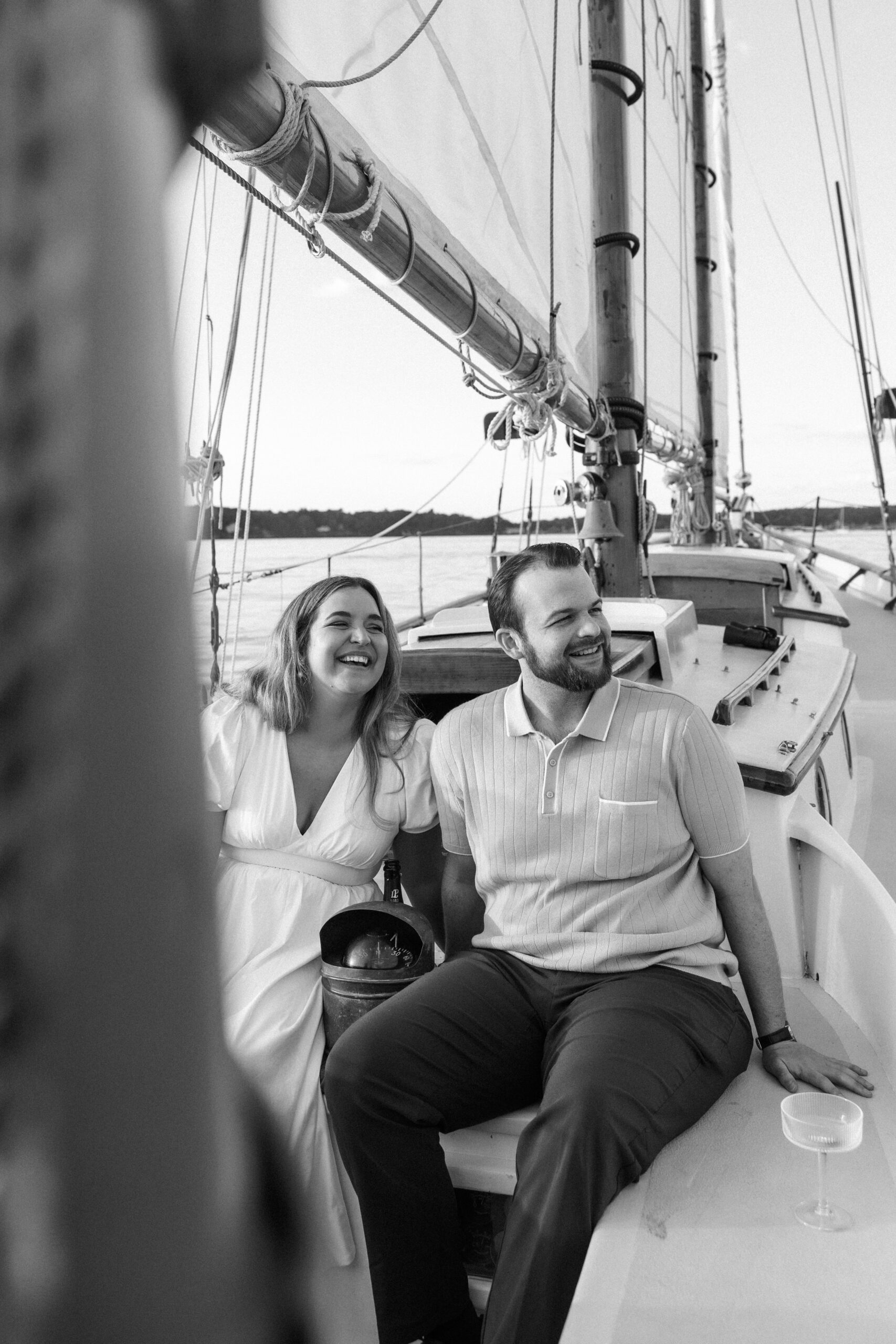 candid photo of couple on sailboat during engagement shoot 