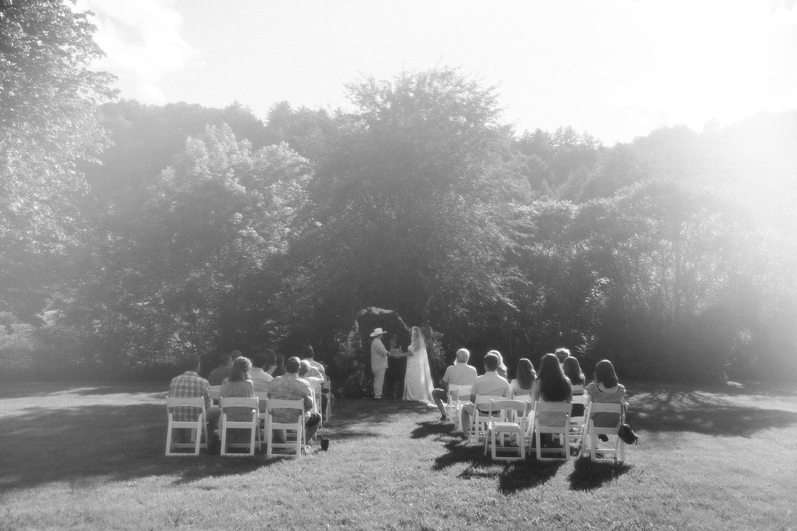 intimate photo of wedding ceremony at a private residence with trees in background