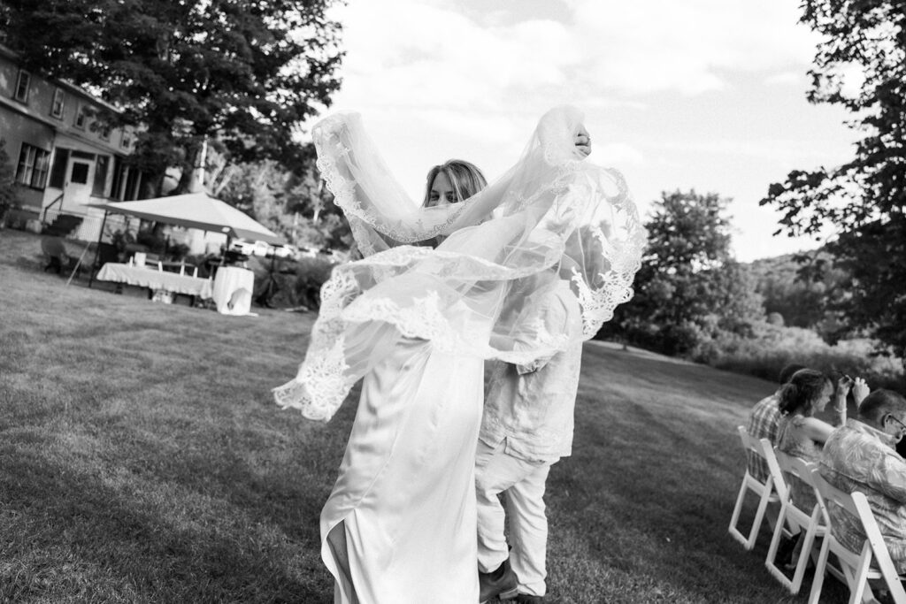 bride playing with her veil after wedding ceremony